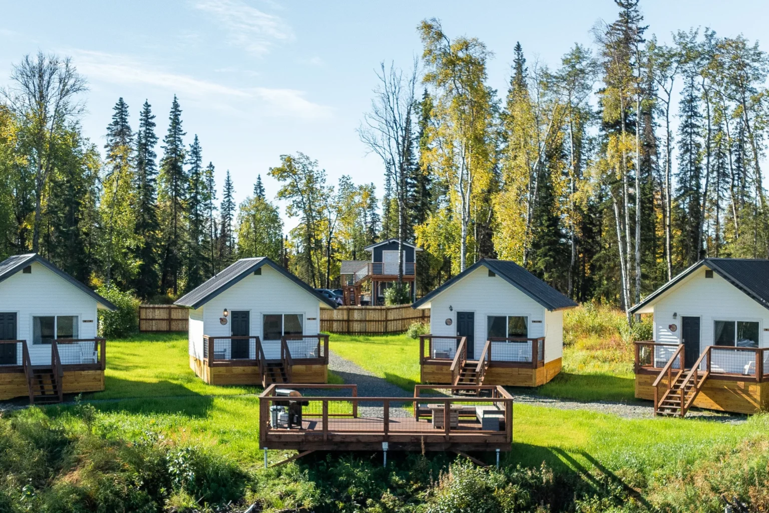 Four Wildflower Ridge cabins with central viewing platform surrounded by Alaska forest